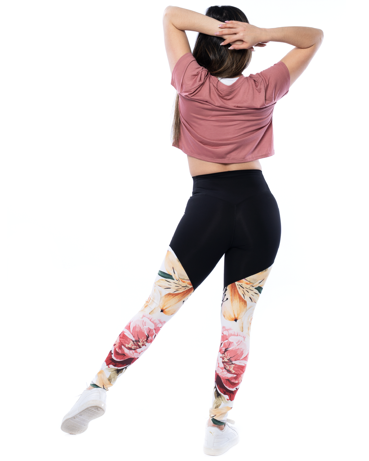model wearing floral leggings and pink crop tee