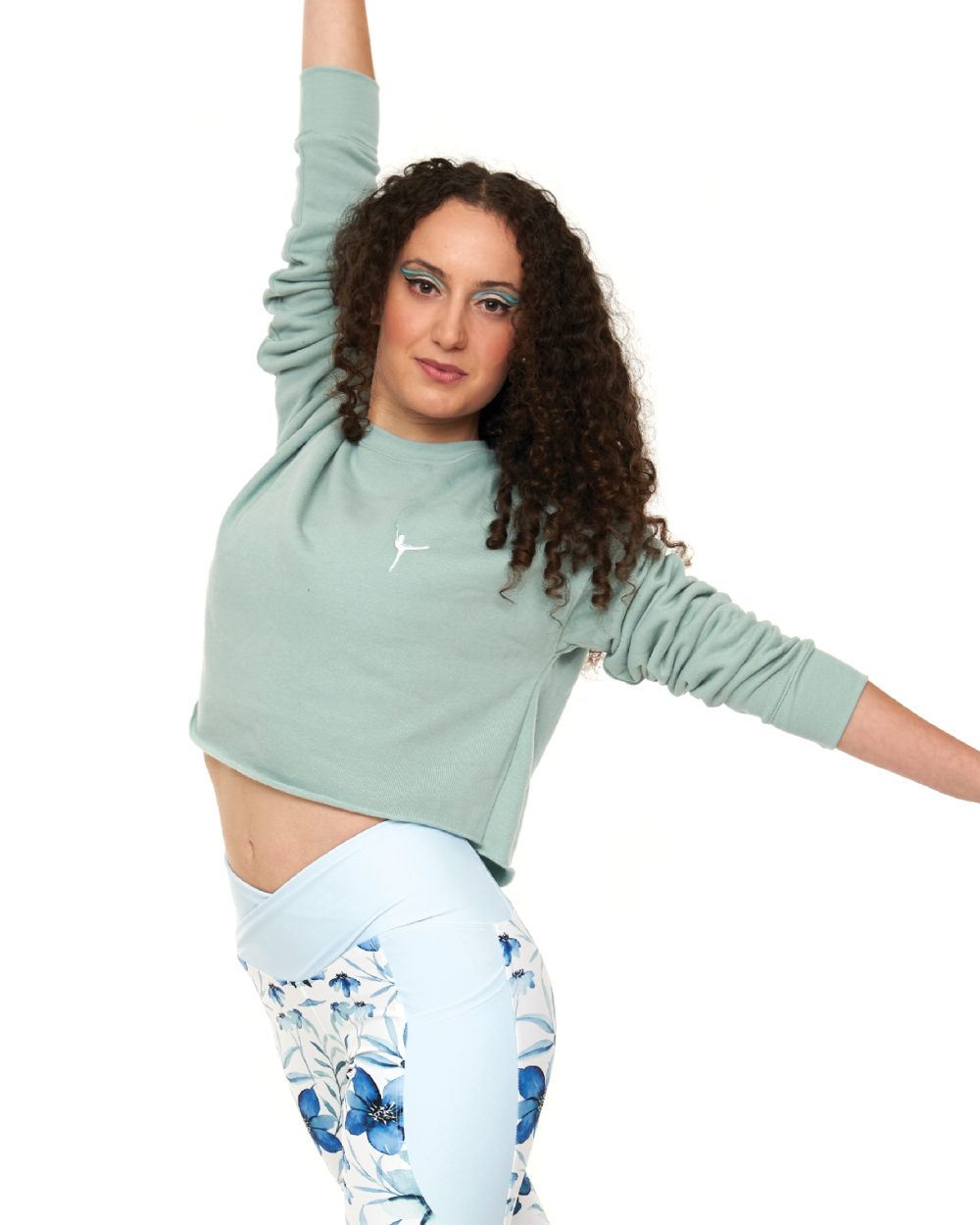 female wearing a blue crop jumper with white embroidered ballerina and floral print leggings