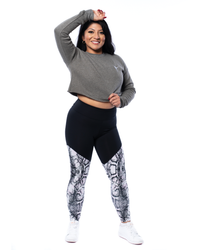 female wearing a grey crop jumper with white embroidered ballerina and animal print snake pattern leggings
