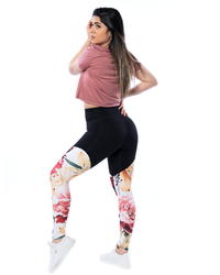 woman wearing high waisted compression leggings in floral pattern with roses and lilies and pink crop tee
