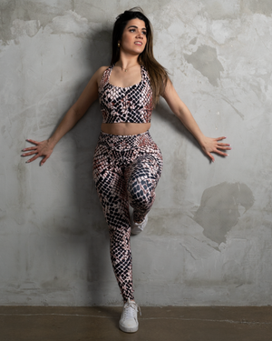 matching set activewear high waisted leggings in animal pattern and longline bra on concrete wall