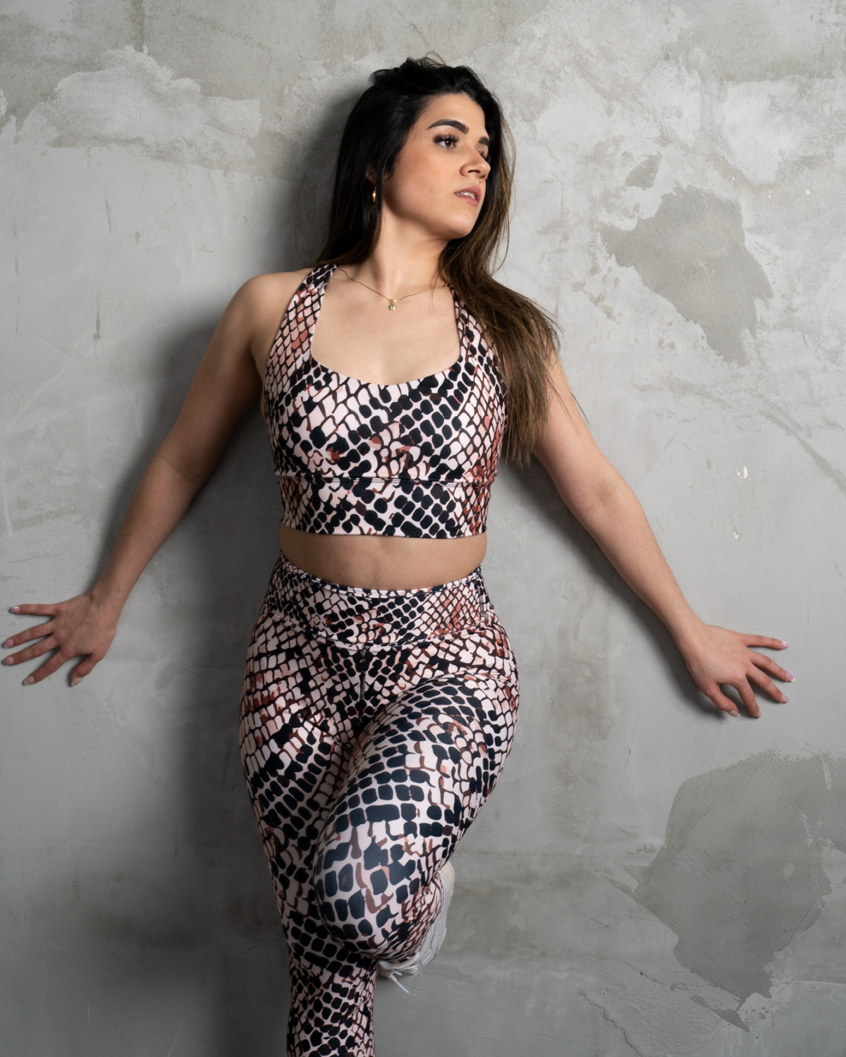 matching set high waisted leggings in animal pattern and crop top on concrete wall